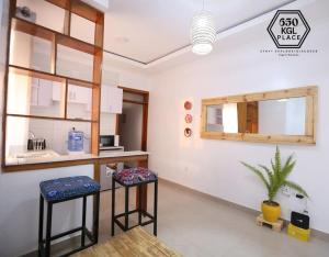 uma cozinha com dois bancos num quarto em Style and Comfort Full Kigali Rwanda Apartment em Kigali