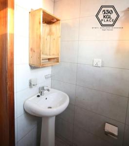 ein Badezimmer mit einem weißen Waschbecken und einem Schrank in der Unterkunft Style and Comfort Full Kigali Rwanda Apartment in Kigali