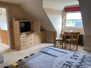 a bedroom with a bed and a tv and a desk at Private room Bishop Norton in Market Rasen