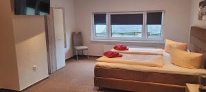 1 dormitorio con 2 camas y ventana en Pension & Gasthof Storchennest en Groß Quassow