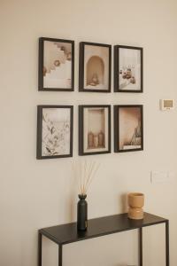 un grupo de fotos en una pared con una mesa en Apartamentos Cervantes, en Badajoz