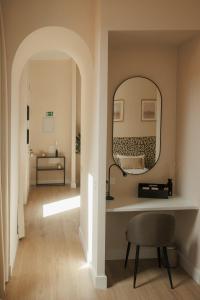 un couloir avec un miroir et une chaise dans l'établissement Apartamentos Cervantes, à Badajoz