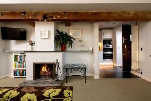 a living room with a fireplace and a tv at Old Round House with hot tub in Padstow