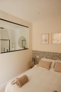 een slaapkamer met een wit bed en een grote spiegel bij Apartamentos Cervantes in Badajoz