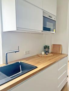 - une cuisine avec un évier et un comptoir en bois dans l'établissement AusZeit - a75482, à Grömitz