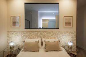 1 dormitorio con espejo grande encima de la cama en Apartamentos Cervantes en Badajoz