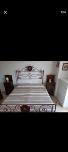 um quarto com uma cama com uma estrutura de metal em A due passi dal mare. em Falconara Marittima