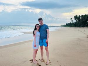 un homme et une femme debout sur la plage dans l'établissement Shine Wave Turtle Beach, à Tangalle