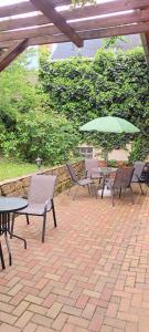a patio with tables and chairs and an umbrella at Orient Apartmanház in Eger