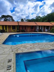 a swimming pool in front of a house at Fazenda Jorge Tardin in Barra Alegre