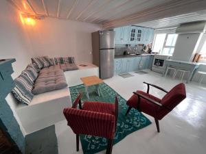 a kitchen and a living room with a couch and chairs at Galaxidi Authentic Rooftop House in Galaxidi
