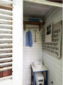 - une salle de bains avec toilettes dans un bâtiment dans l'établissement Mysig stuga i Rute med stor trädgård, à Lärbro