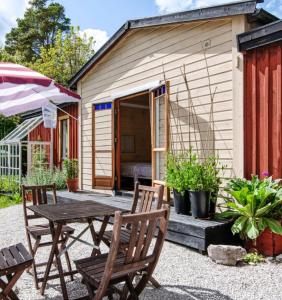 einem Picknicktisch und Stühlen vor einem Schuppen in der Unterkunft Mysig stuga i Rute med stor trädgård in Lärbro