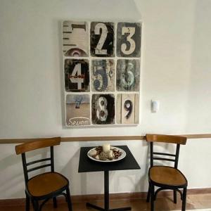 a table with two chairs and a clock on the wall at Thalia Hotel in Kamena Vourla