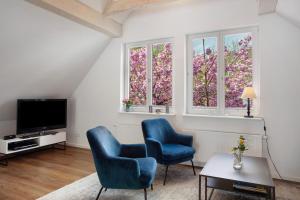 - un salon avec 2 chaises bleues et 2 fenêtres dans l'établissement Gut Vasbach Ferienwohnungen, à Kirchhundem