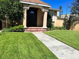 uma casa com uma porta preta e um jardim de relva em An Amazing comfortable home front house em Los Angeles
