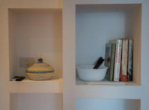 een plank met boeken, een kom en een vaas bij Adagio Suite in Rapallo +29 foto's