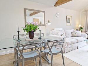 a living room with a glass table and chairs at The Shed - Pulborough in Pulborough