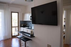 een televisie aan een muur in een keuken bij Adagio Suite in Rapallo