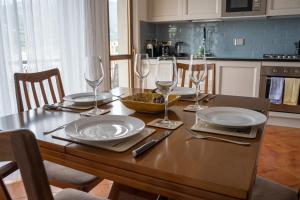 een houten tafel met borden en wijnglazen erop bij Adagio Suite in Rapallo
