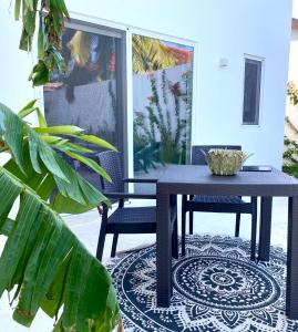 - une table et deux chaises sur la terrasse dans l'établissement Lions Grand SUITE Ocean Front Beach & Pool, à Bunju