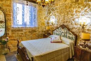 a bedroom with a bed and a stone wall at El Rincón de Hornuez 