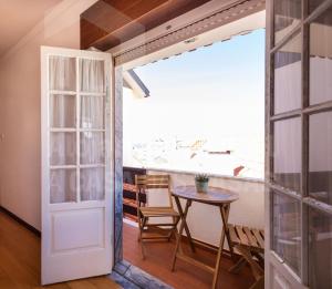 a door leading into a dining room with a table at Casa do Pedro by ACasaDasCasas in Ericeira