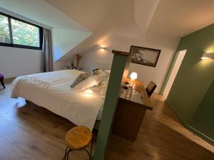 um quarto com uma cama grande e uma janela em Manoir des Eperviers em Quéven