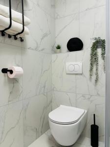 ポルトロスにあるLuxury apartment magical Portoroseの白いバスルーム(トイレ、一部の植物付)