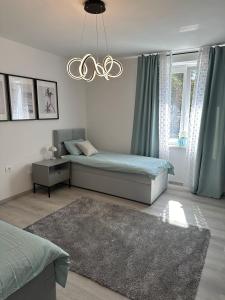 een slaapkamer met 2 bedden en een kroonluchter bij Luxury apartment magical Portorose in Portorož