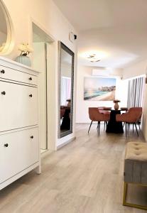 een woonkamer met een witte dressoir en een tafel bij Luxury apartment magical Portorose in Portorož