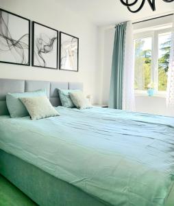 biała sypialnia z dużym łóżkiem z niebieską pościelą w obiekcie Luxury apartment magical Portorose w Portorožu