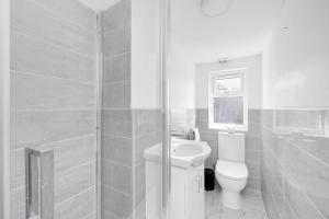 a bathroom with a toilet and a sink and a shower at Pass the Keys Beautiful spacious 7 bed in Hornchurch