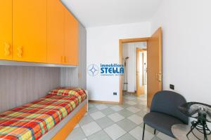 a room with a bed and a chair and a door at Villaggio Papaia in Lido di Jesolo +25 photos