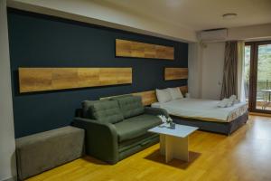 a living room with a couch and a bed at Park Golden View Hotel Casino in Ohrid
