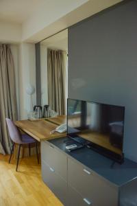 uma sala de estar com uma mesa e uma televisão grande em Park Golden View Hotel Casino em Ohrid