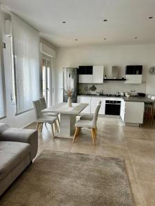 sala de estar con mesa y sillas y cocina en L’approdo a Porto Torres, en Porto Torres