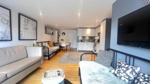 un soggiorno con divano e TV a schermo piatto di Cosy Ground Floor Apartment a Londra