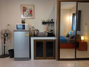 Il comprend une petite cuisine équipée d'un réfrigérateur et d'un lit. dans l'établissement Cozy BangTao Studio 7 by Bcare, à Ban Thalat Choeng Thale
