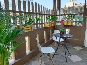 d'un balcon avec une table, des chaises et des plantes en pot. dans l'établissement Cozy BangTao Studio 7 by Bcare, à Ban Thalat Choeng Thale