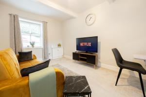 a living room with a couch and a tv at Church Street Cottage Great Harwood in Great Harwood