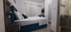 a bedroom with a blue and white bed and a sink at Apartments & Rooms Jure in Viniština