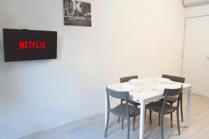 einen weißen Tisch mit Stühlen und ein Schild mit Netflix in der Unterkunft CE6 - [Corso Sempione] • Large Apartment in Mailand