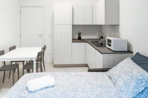 Zimmer mit einem Bett und einer Küche mit einer Mikrowelle in der Unterkunft CE6 - [Corso Sempione] • Large Apartment in Mailand