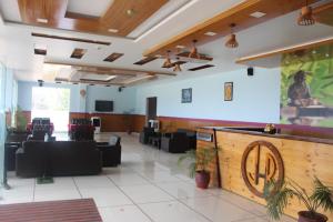 a lobby with a waiting area with tables and chairs at Jai Hotel By Boho in Pālampur