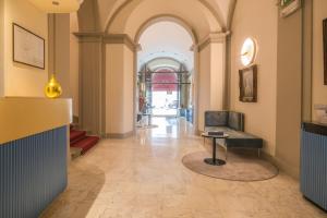 un corridoio con una sedia e un tavolo in un edificio di Bosone Palace a Gubbio