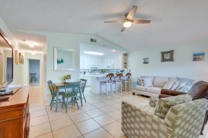 a living room and kitchen with a couch and a table at Cozy PCB Condo Less Than half Mile to Public Beach Access! in Panama City Beach