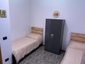 Cette chambre comprend deux lits et une armoire noire. dans l'établissement Intero appartamento - Parma zona Fiera, à Roncopascolo