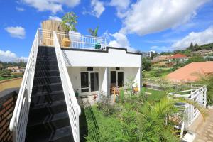 a white house with a balcony on top of it at Cozy Oasis Large Apt in Center of Kigali Rwanda in Kigali