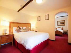 a bedroom with a large bed with a red carpet at The Rose And Crown Hotel in Wisbech